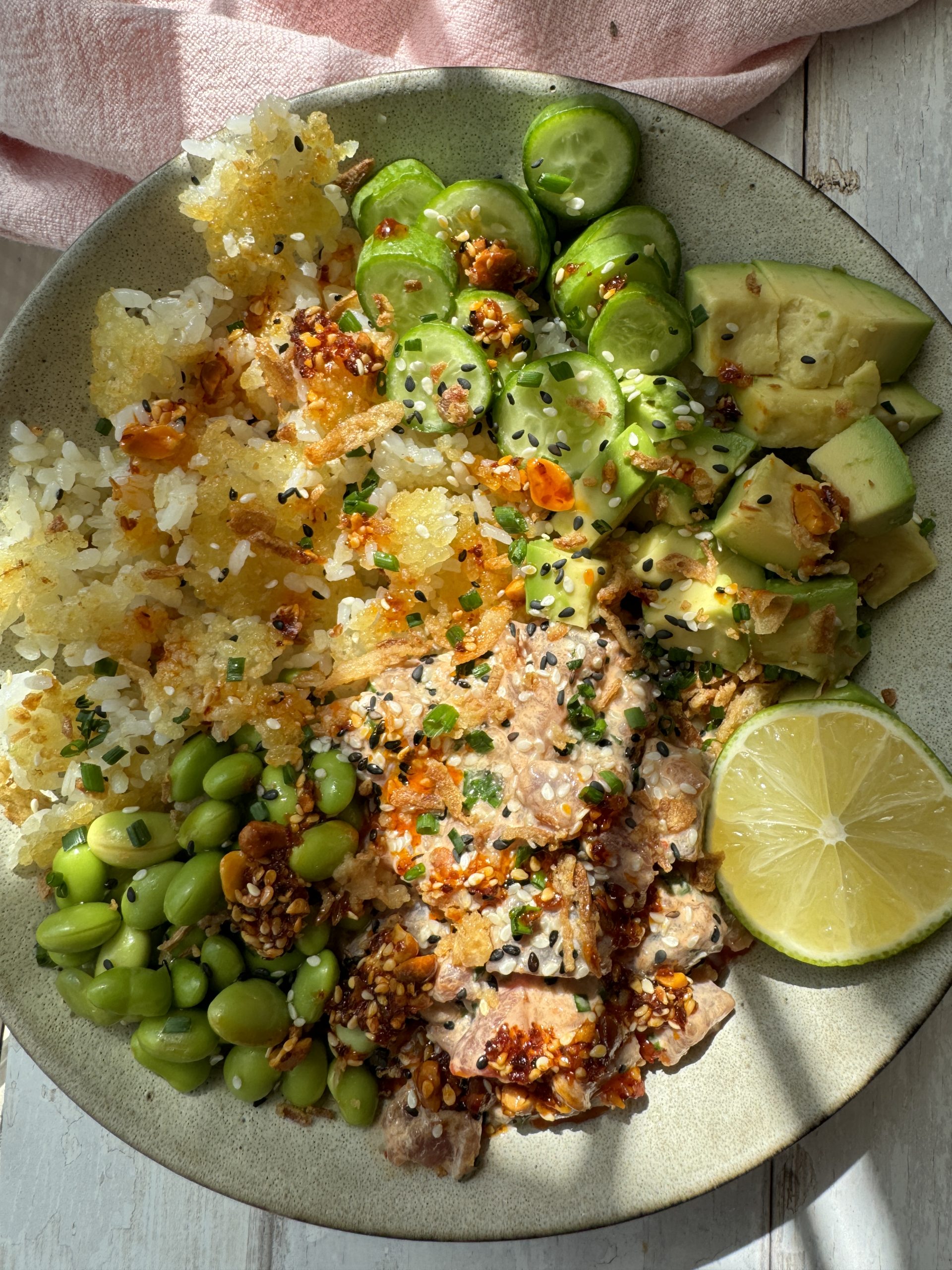 spicy tuna in a bowl with crispy rice and cucumber and avocado