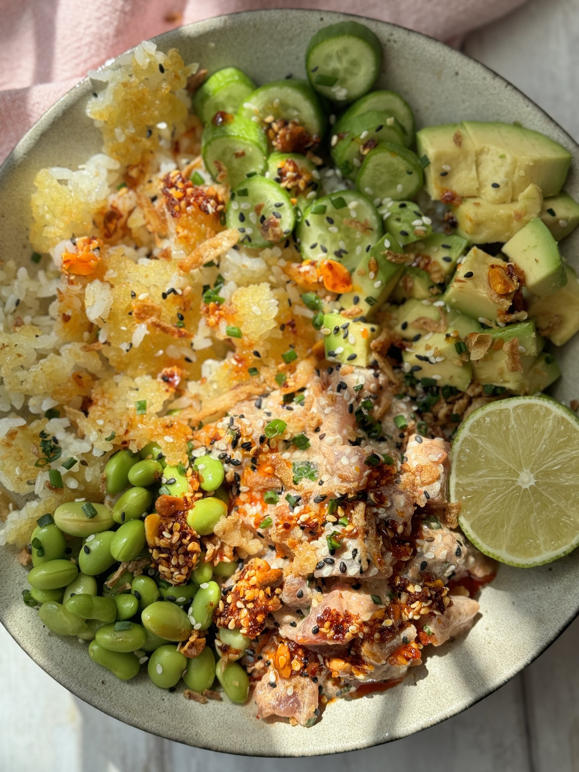 spicy tuna in a bowl with crispy rice and cucumber and avocado