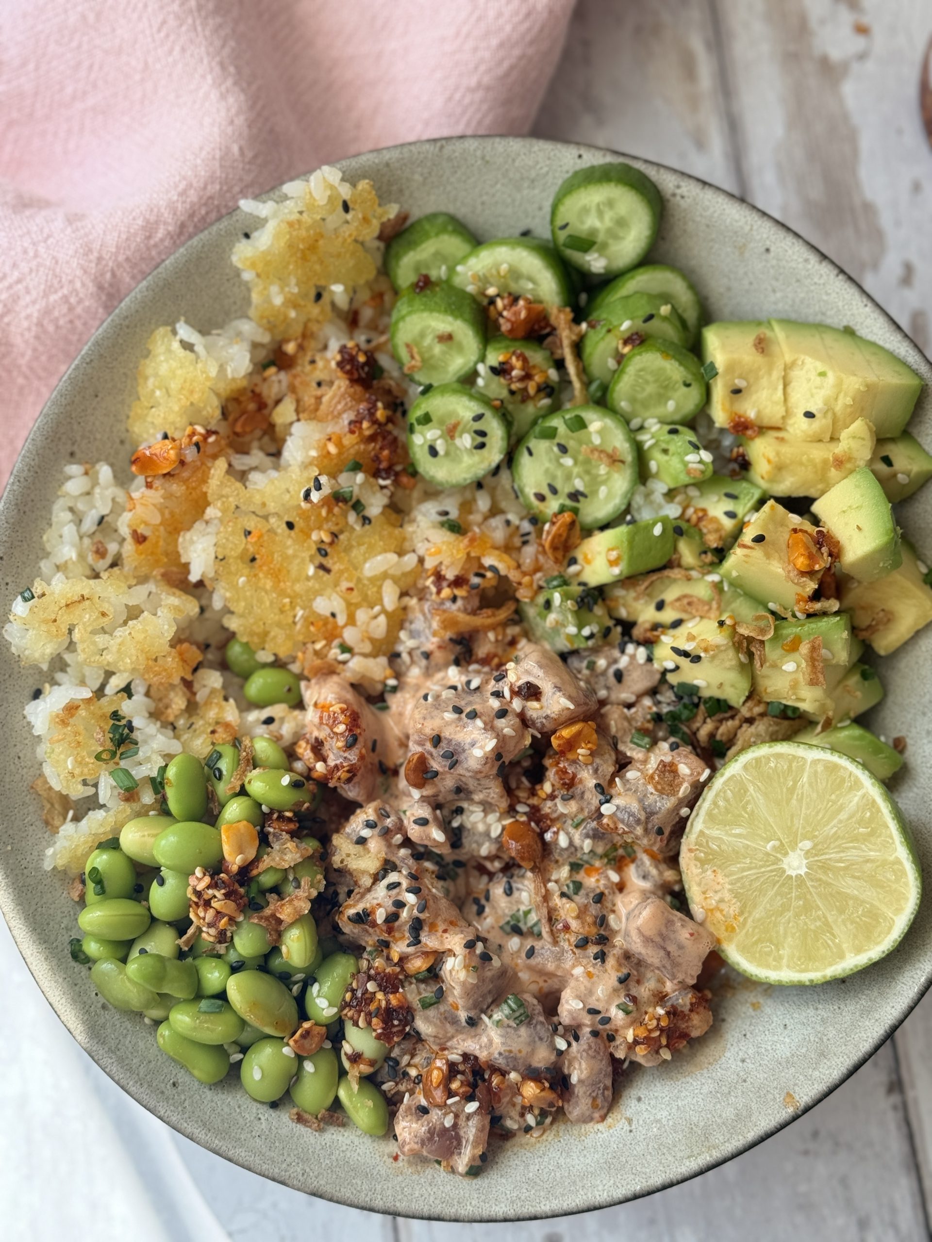 spicy tuna in a bowl with crispy rice and cucumber and avocado