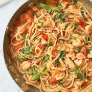 a pan of prawn tomato linguine on a white table