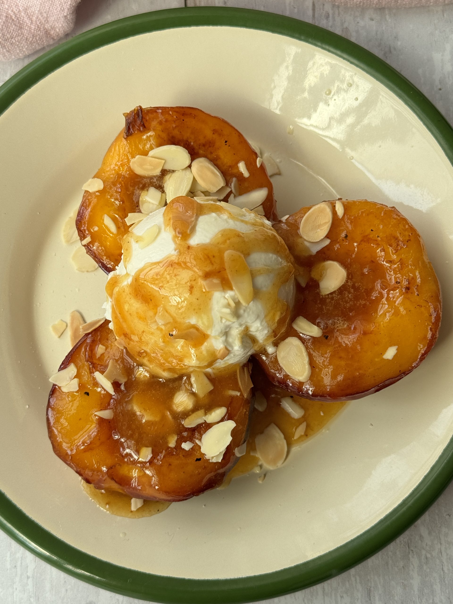 peaches and cream on a white plate with green trim