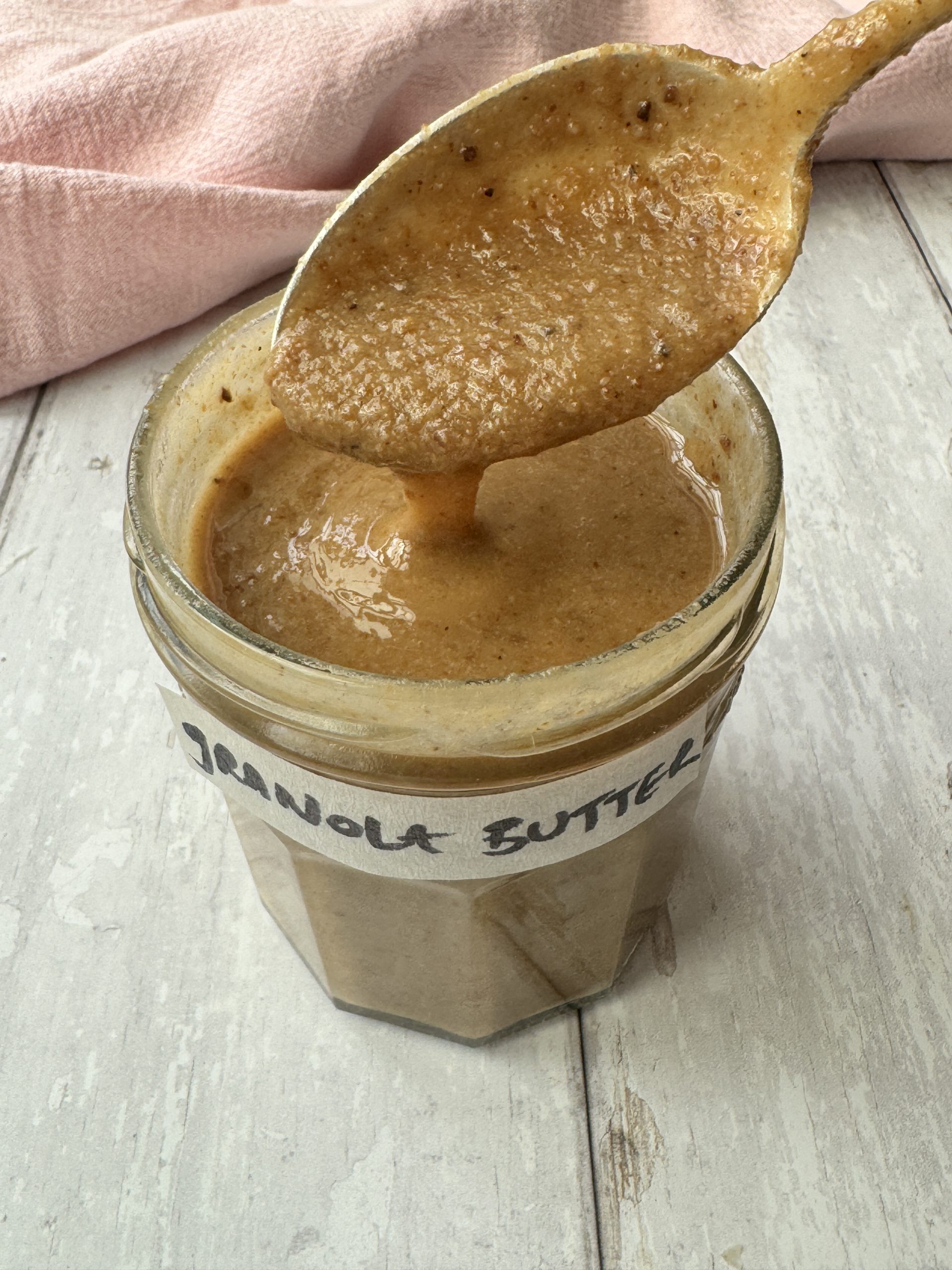 a jar of granola butter with a spoon and a label that reads granola butter