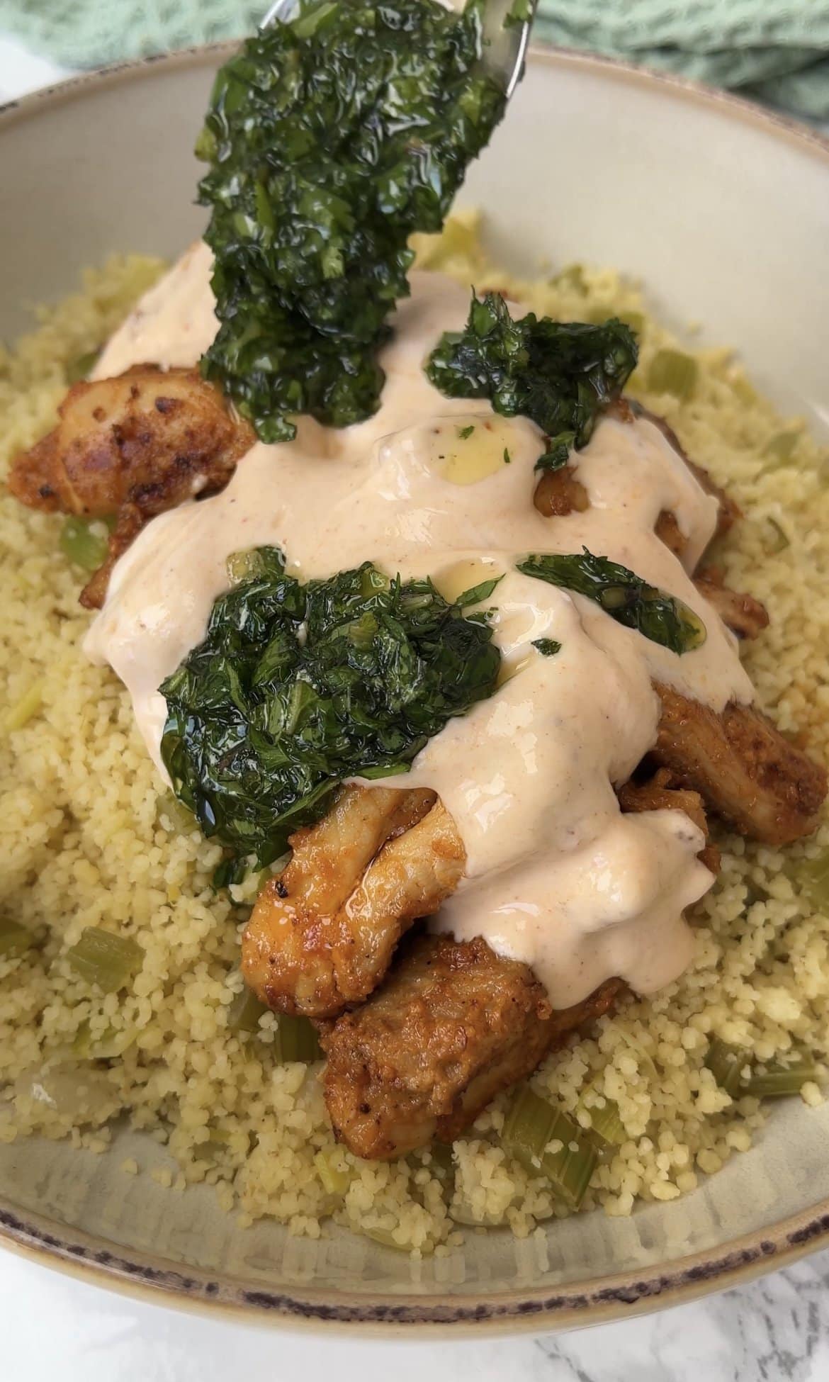 topping chicken and couscous with herby drizzle.