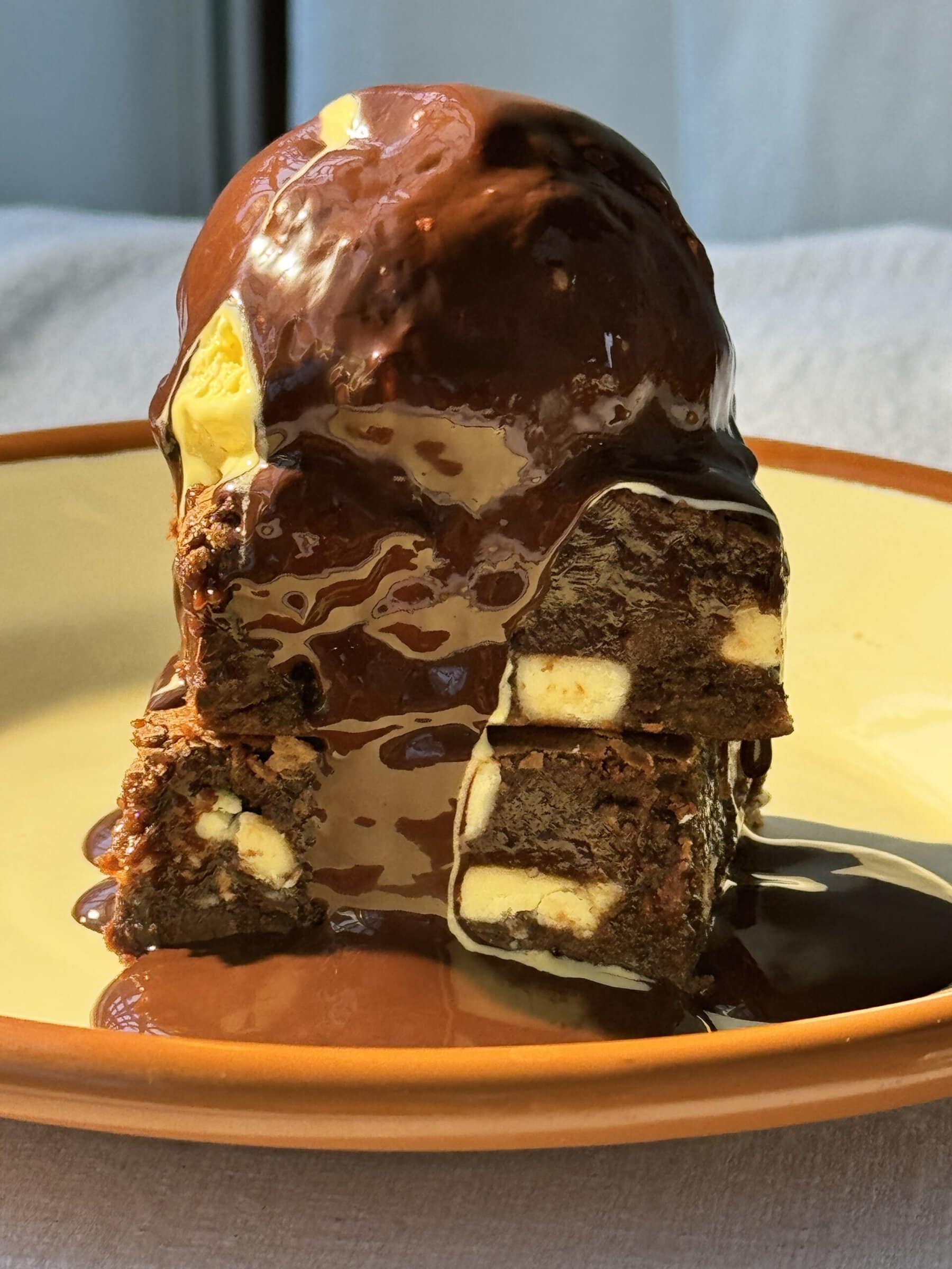 chocolate and white chocolate brownies stacked with ice cream on top.