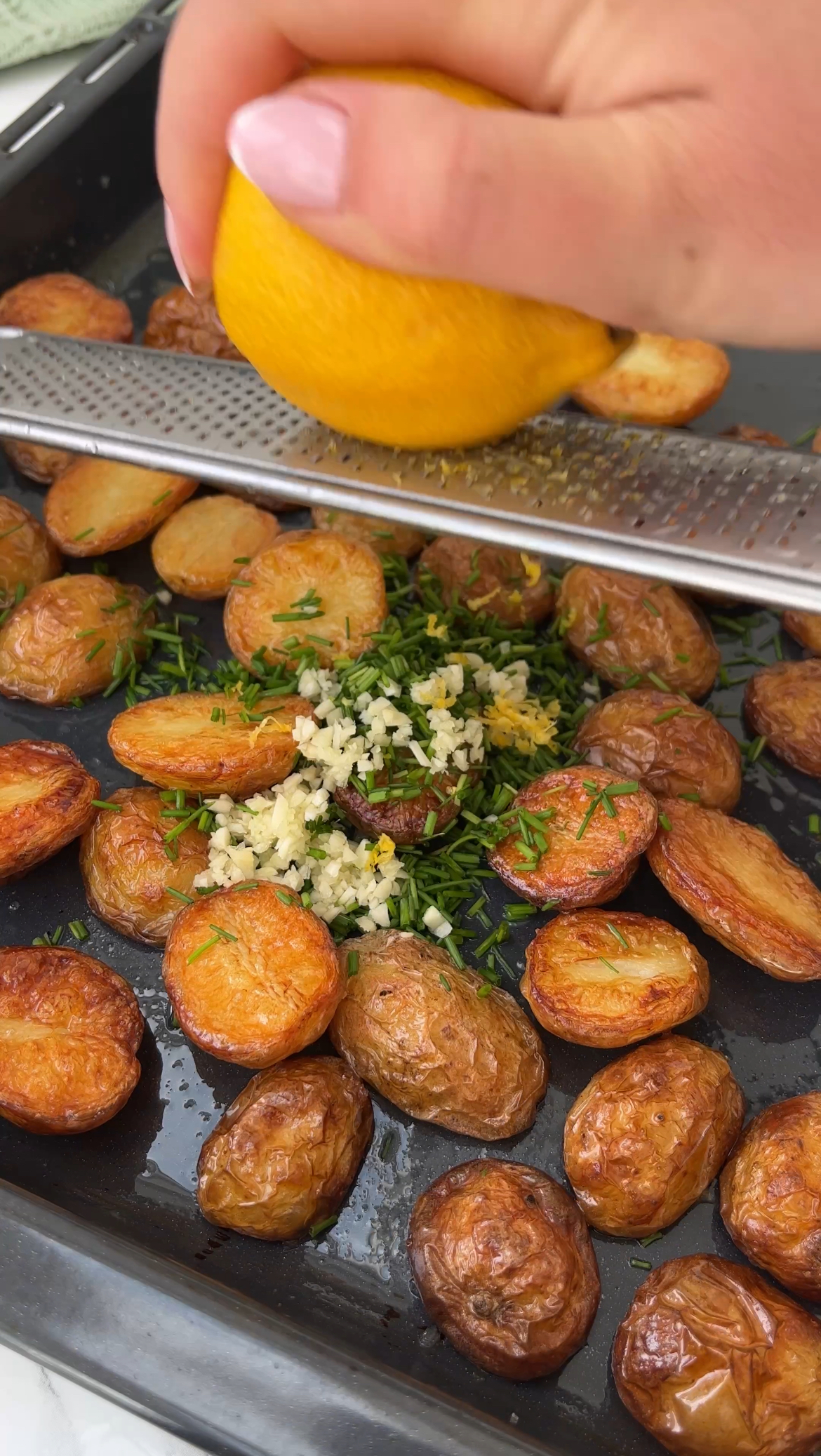 adding herbs to the roasted potatoes