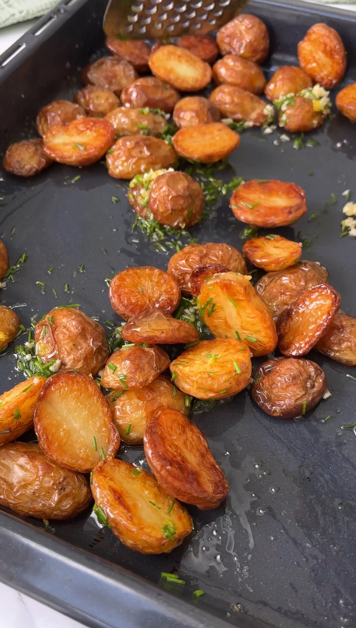 tossing roasted potatoes with herbs