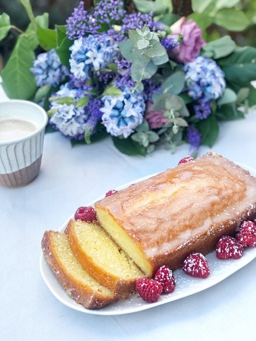 lemon loaf cake sliced with raspberries.