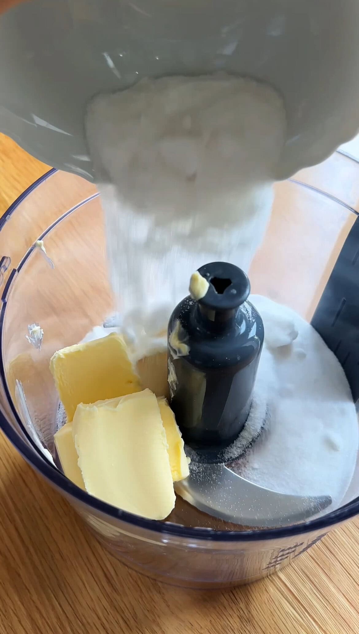 adding sugar to the food processor.