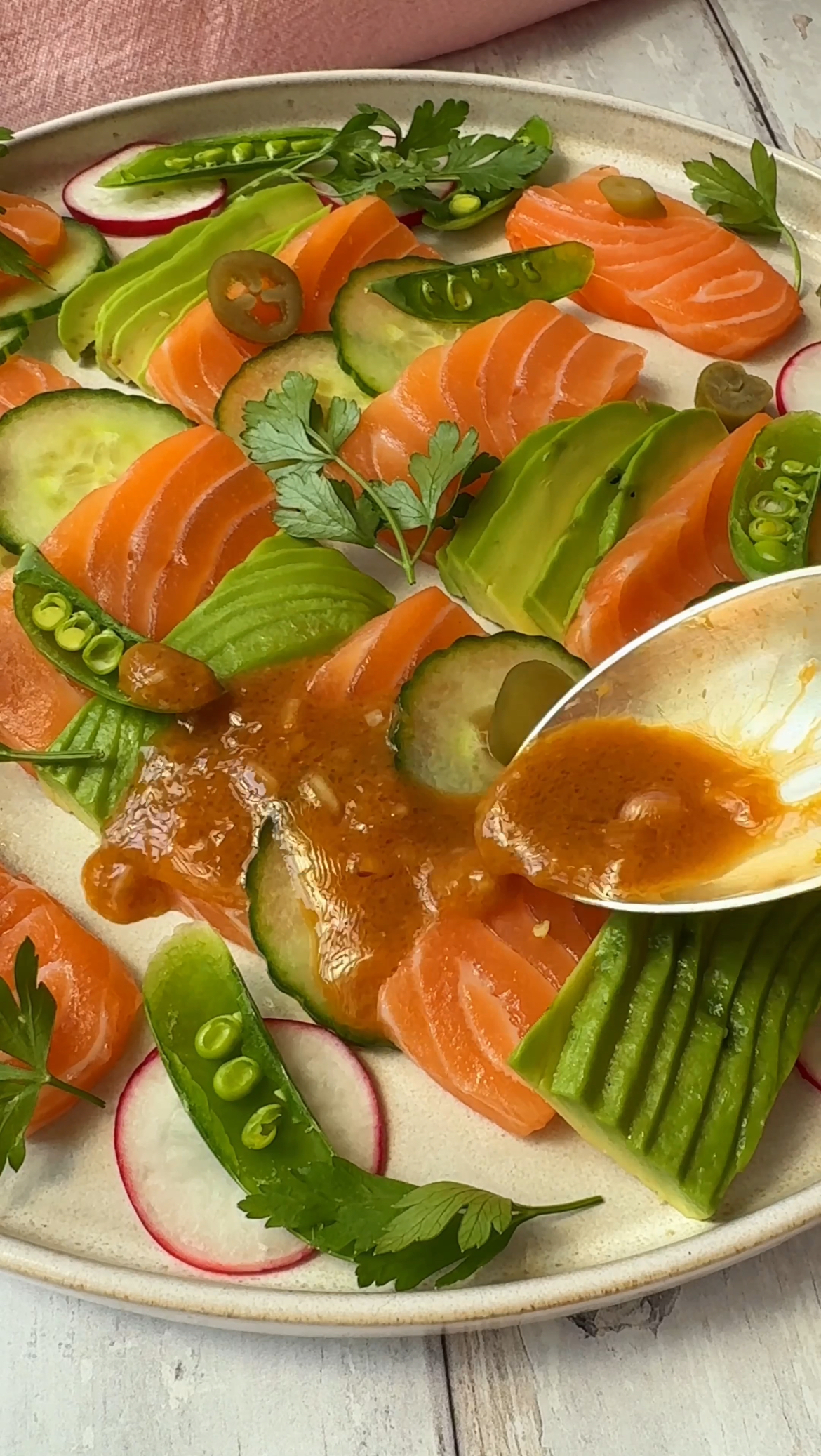 spooning dressing over salmon crudo