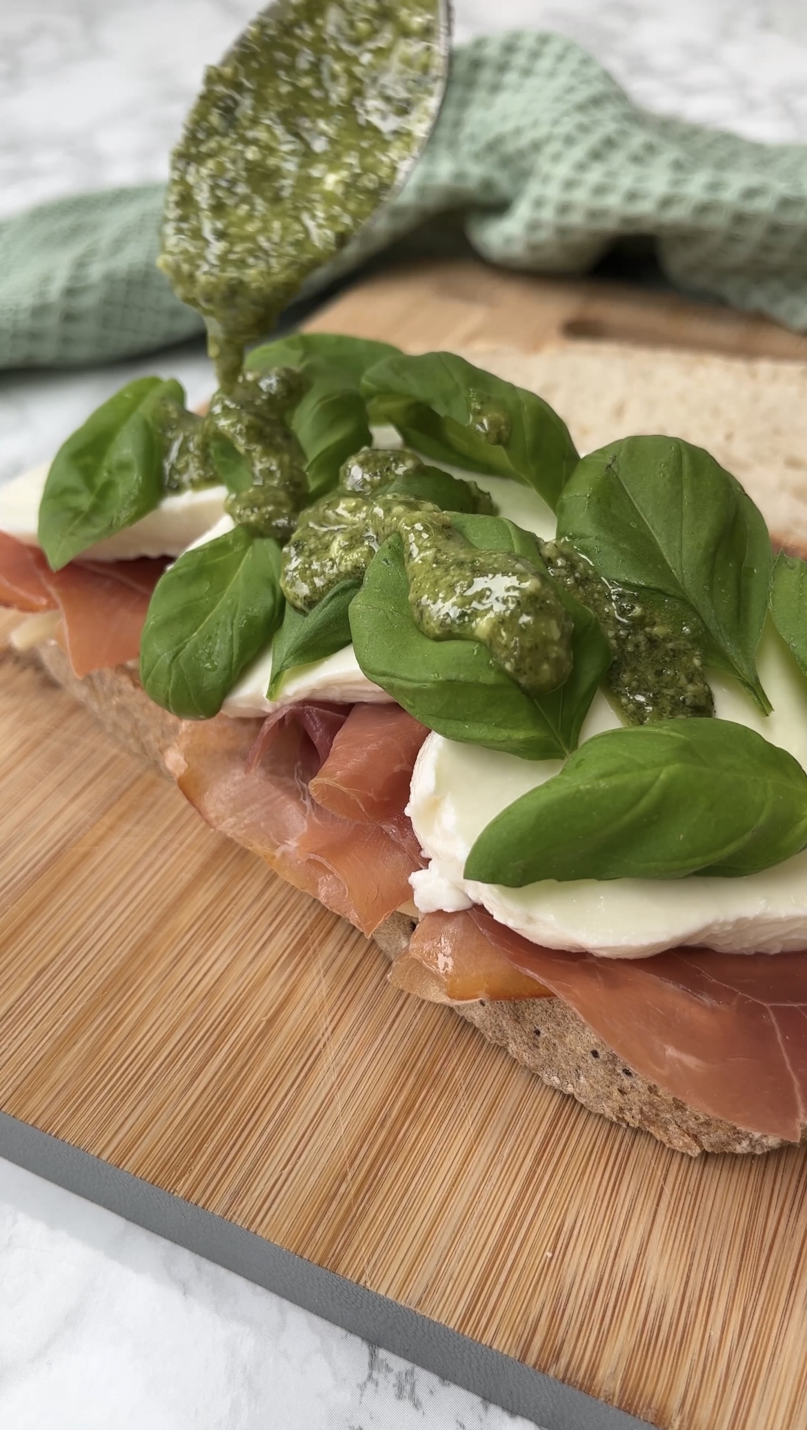 drizzling the sandwich with pesto