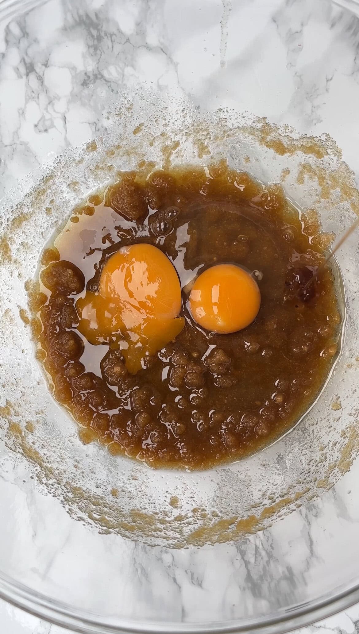 adding eggs to the cookie dough.