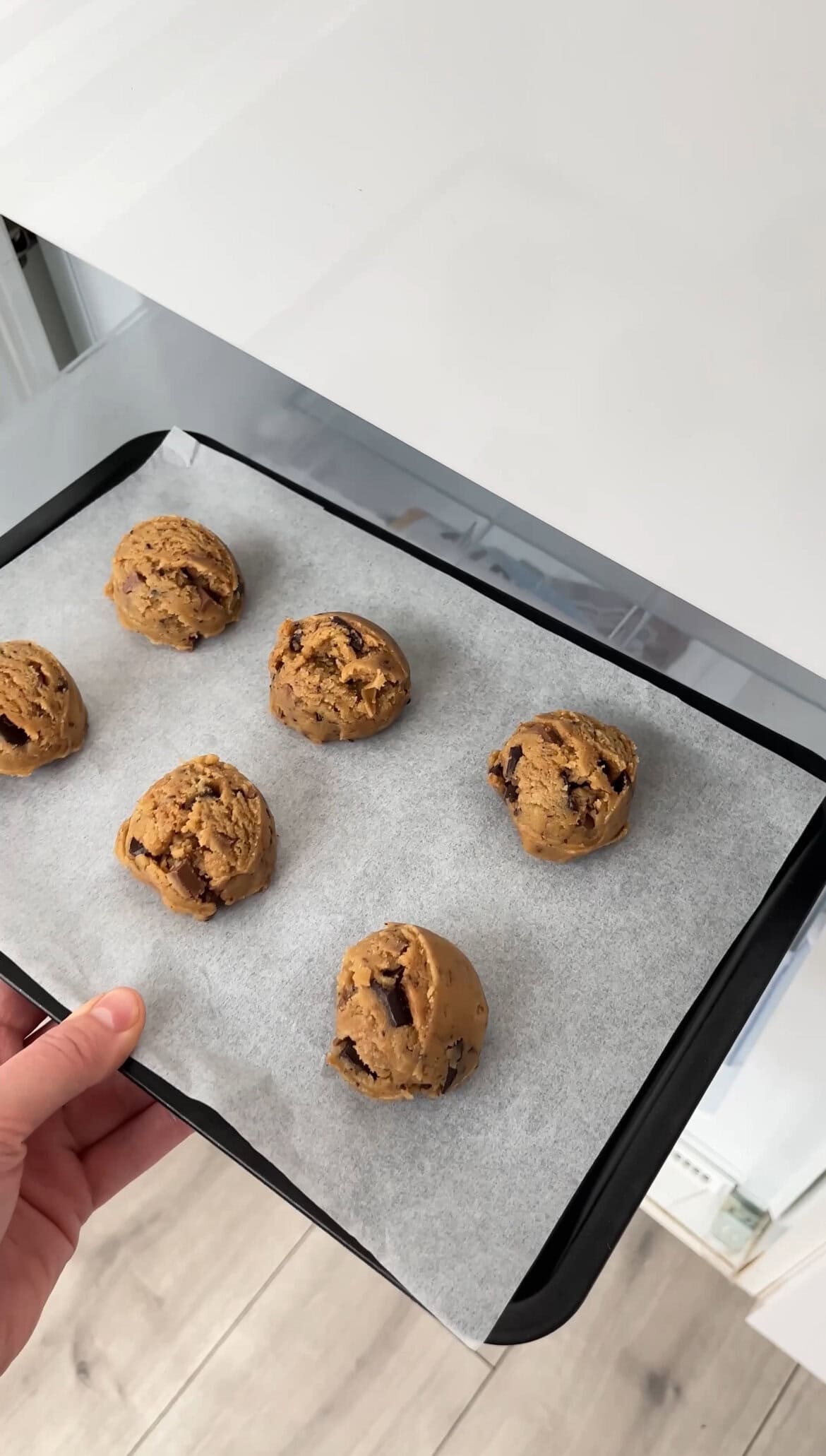 triple chocolate chunk cookies on a tray in the freezer.