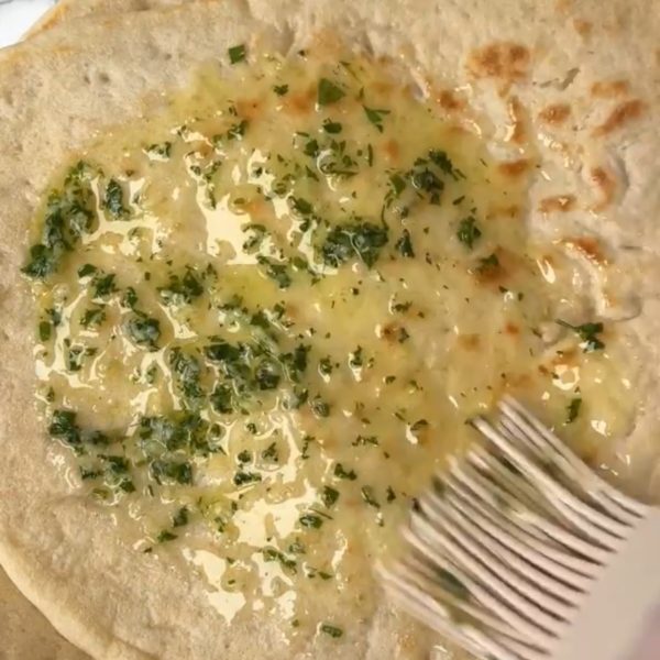 Brushing garlic butter on yoghurt naan