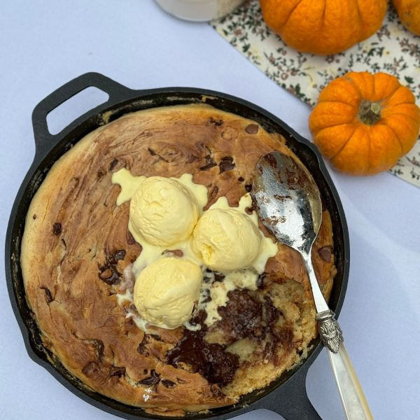 Chocolate Chip giant cookie in a pan with melted vanilla ice cream on top