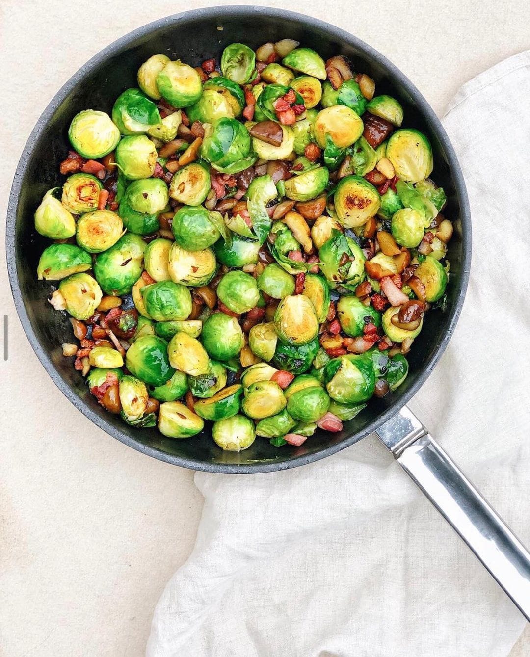 Brussel sprouts, chopped chestnuts and bacon in a silver pan