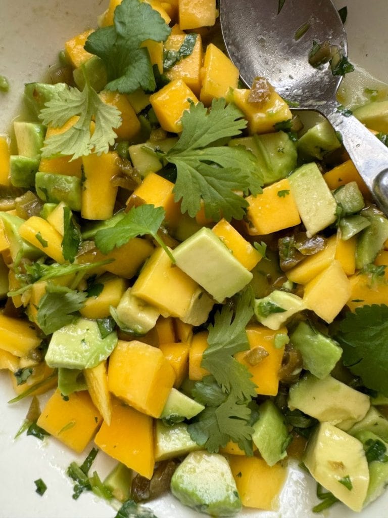 Close up of a mango and avocado salad with pickled jalapenos and coriander. 