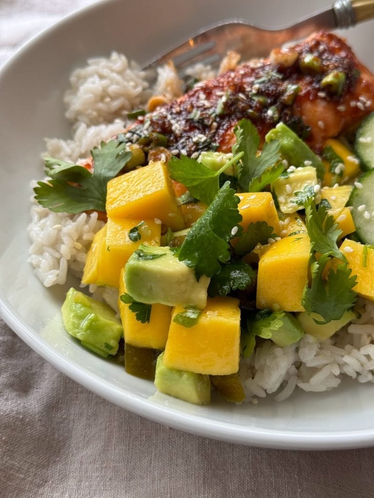 Close up of a mango and avocado salad on a rice bowl.