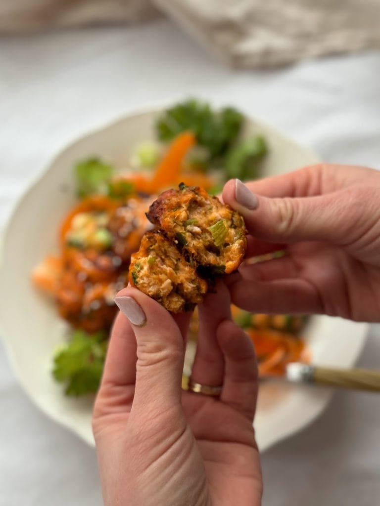 A Korean salmon fishcake being torn open to show the flaky middle.