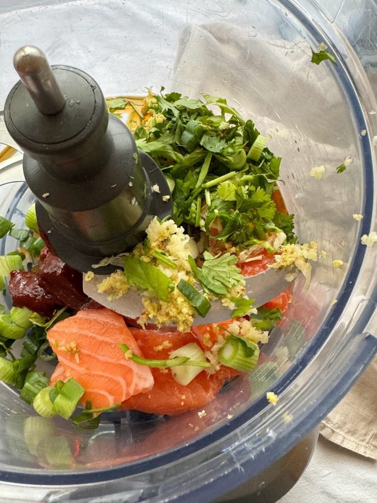 Ingredients to make Korean-inspired salmon fishcakes in the body of a food processor. 