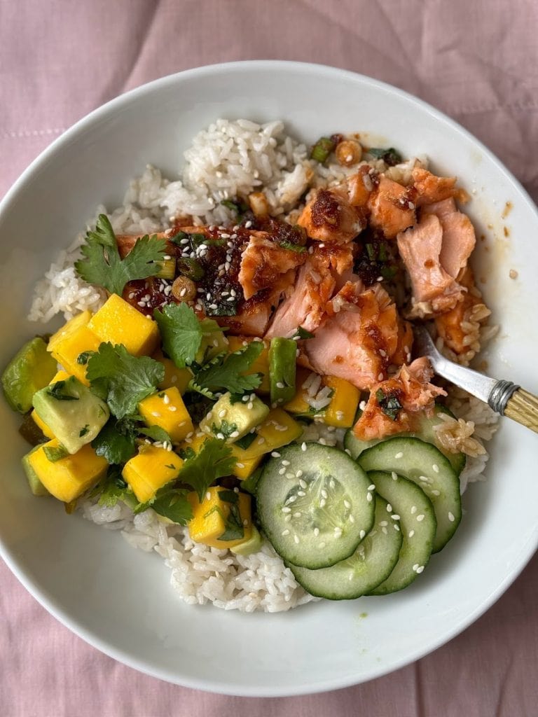 Close up of a teriyaki salmon bowl with the salmon flaked into the rice.