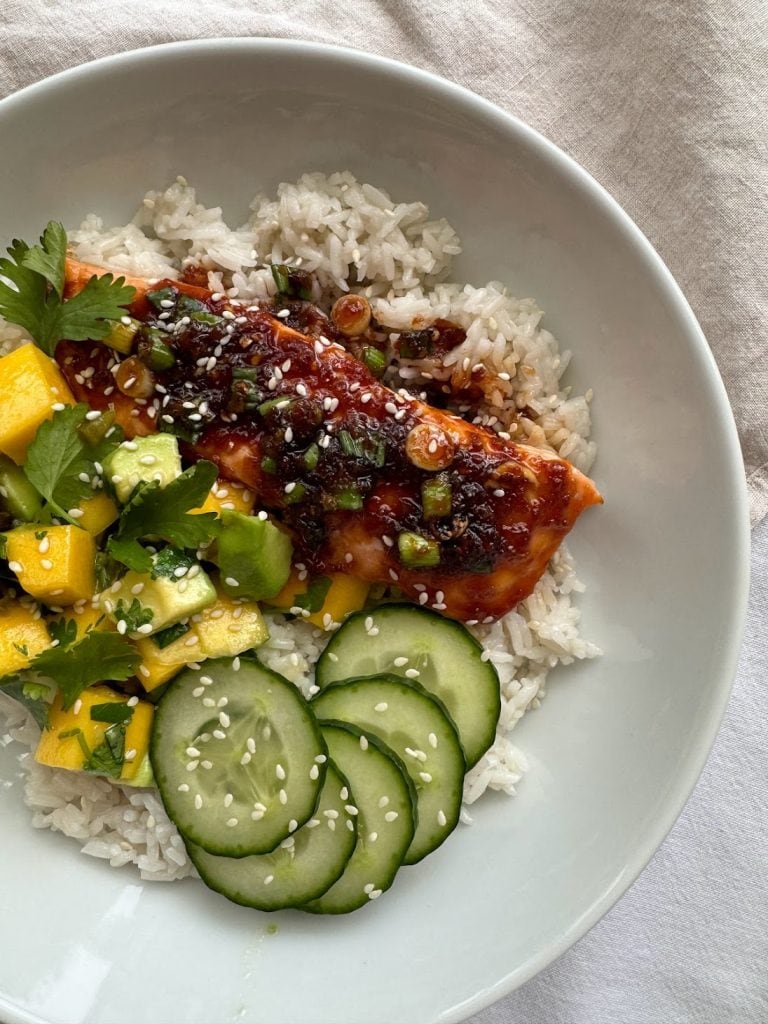 Sushi bowl with terikayo salmon, sliced cucumber and a mango and avocado salad.