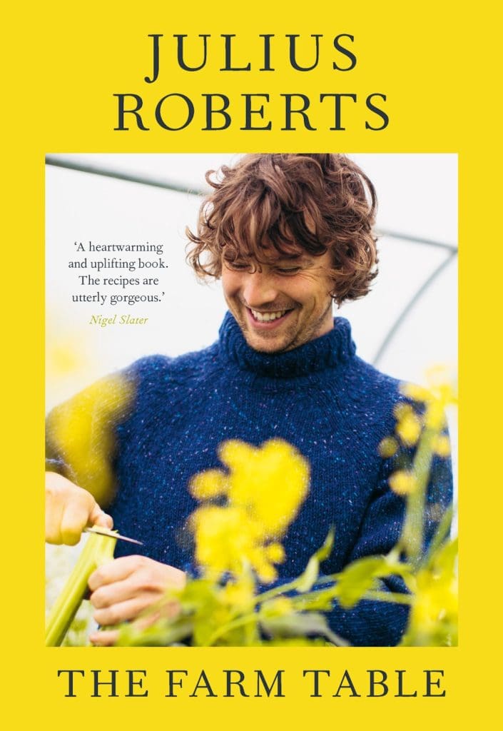 Julius Roberts smiling with flowers in the forefront on a book cover