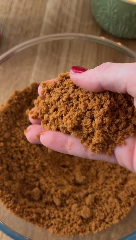 Woman feeling the texture of the biscuits in the Biscoff cheescake base