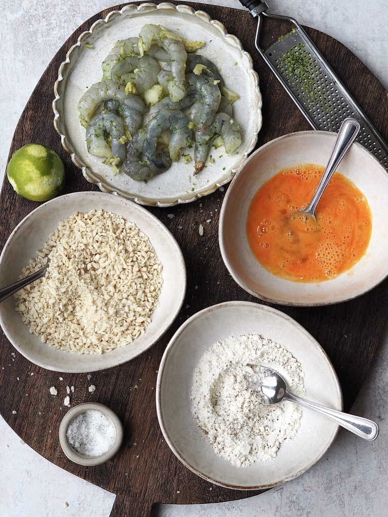 Ingredients to make crispy prawns on a wooden board.