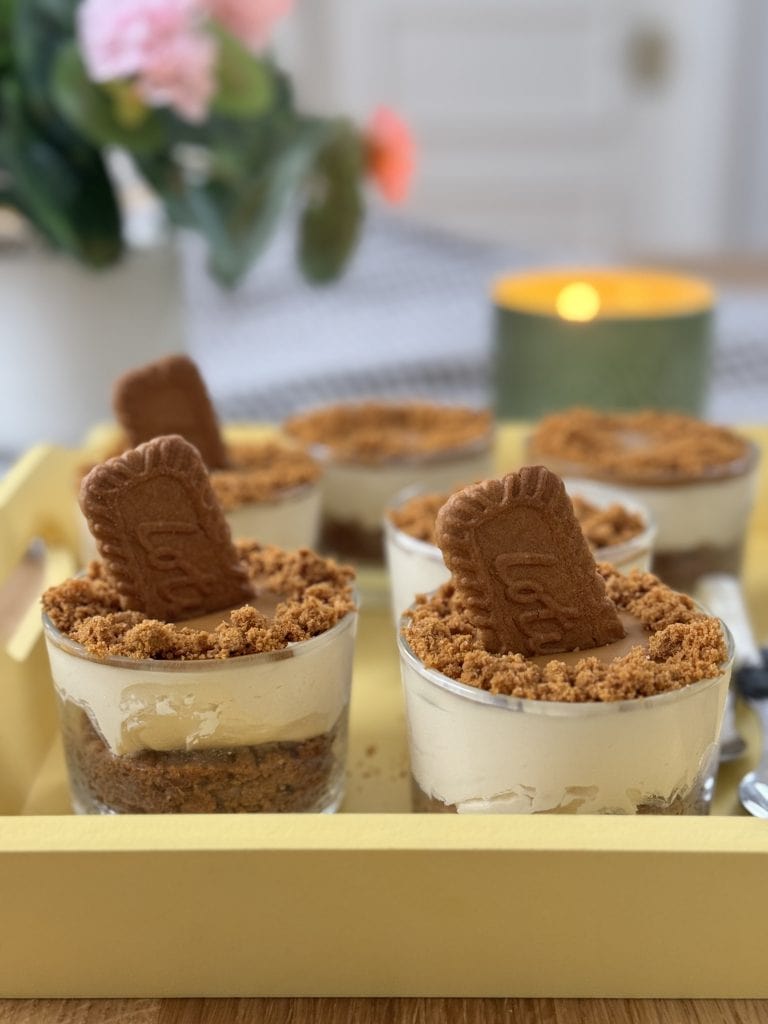 No bake biscoff cheesecakes with Biscoff biscuits in the middle on a yellow tray