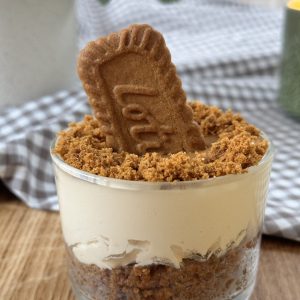 A no bake biscoff cheesecake with a Biscoff biscuit in the middle