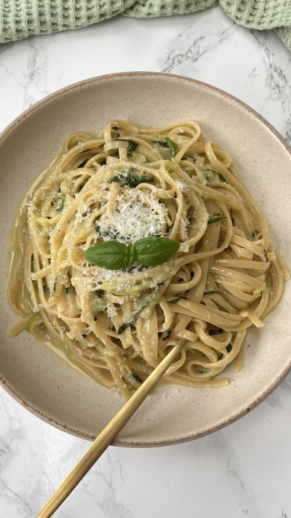 Lemon Courgette Pasta in a beige bowl with a fork in the pasta