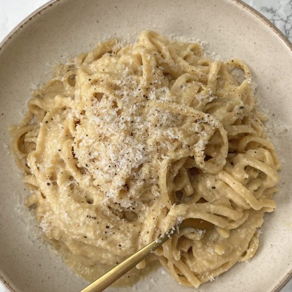 Brown Butter Pasta with Caramelised Onions with a fork in the pasta in a beige bowl