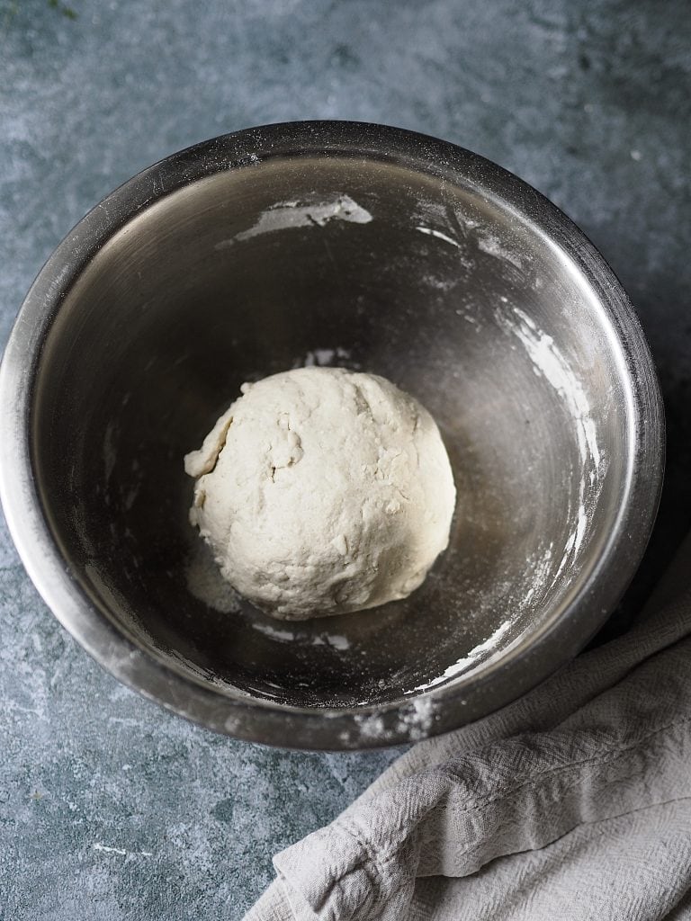 Resting dough in a metal bowl.