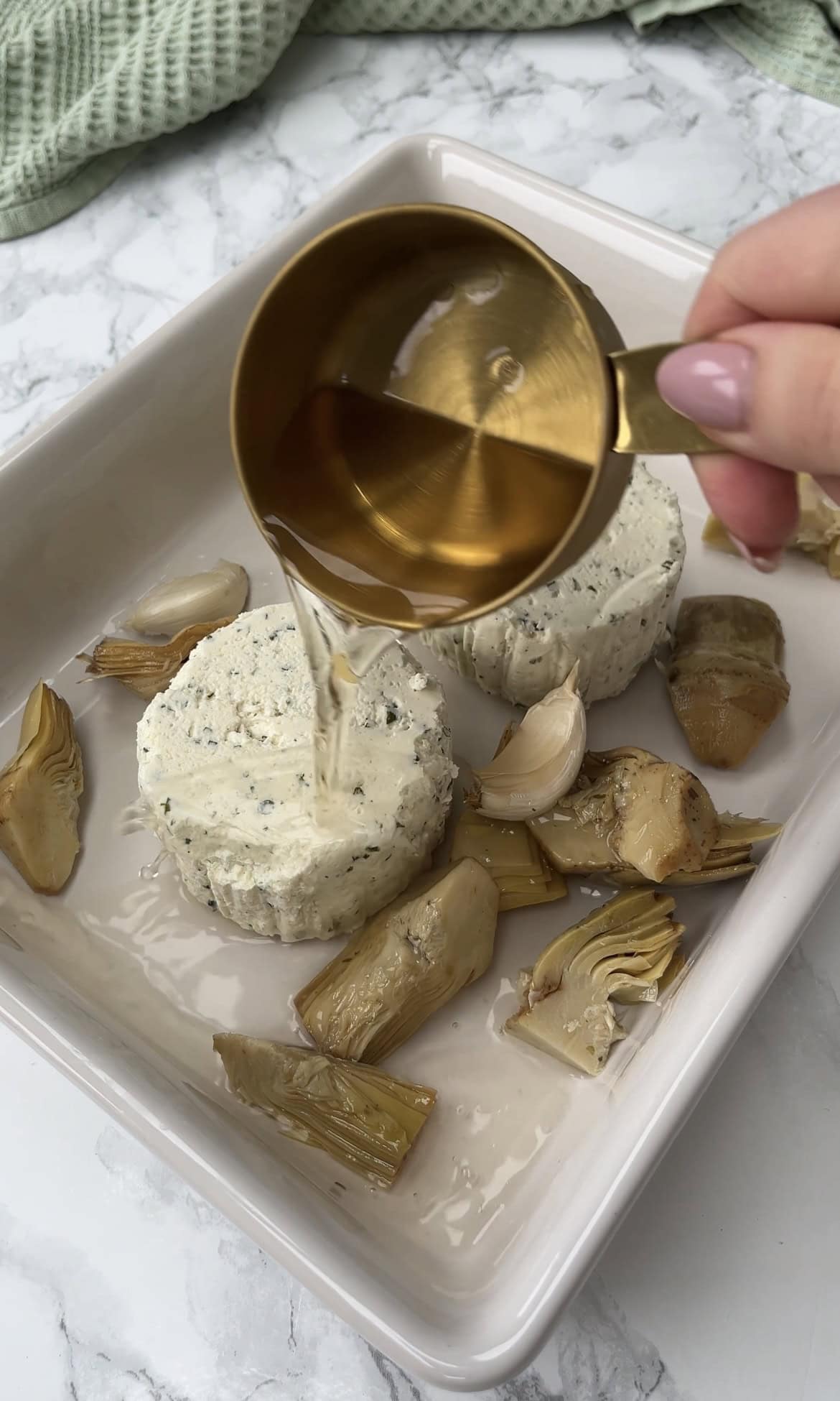 adding water to boursin and artichokes.