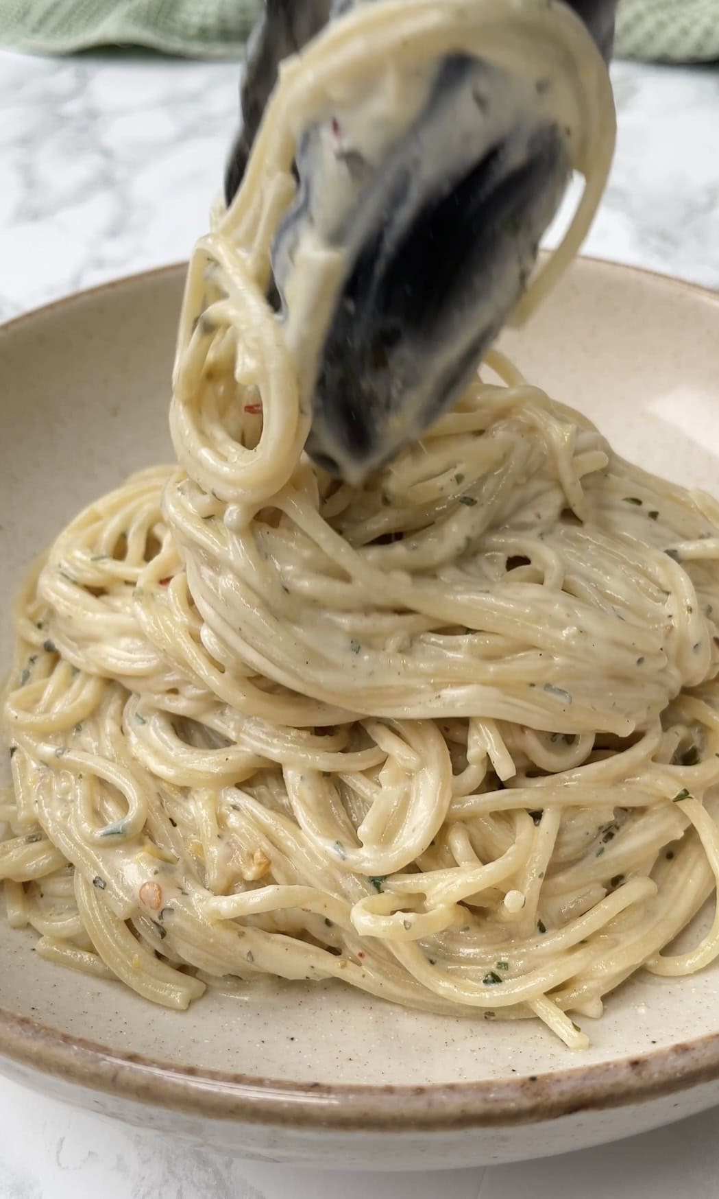 adding baked boursin pasta to bowls.