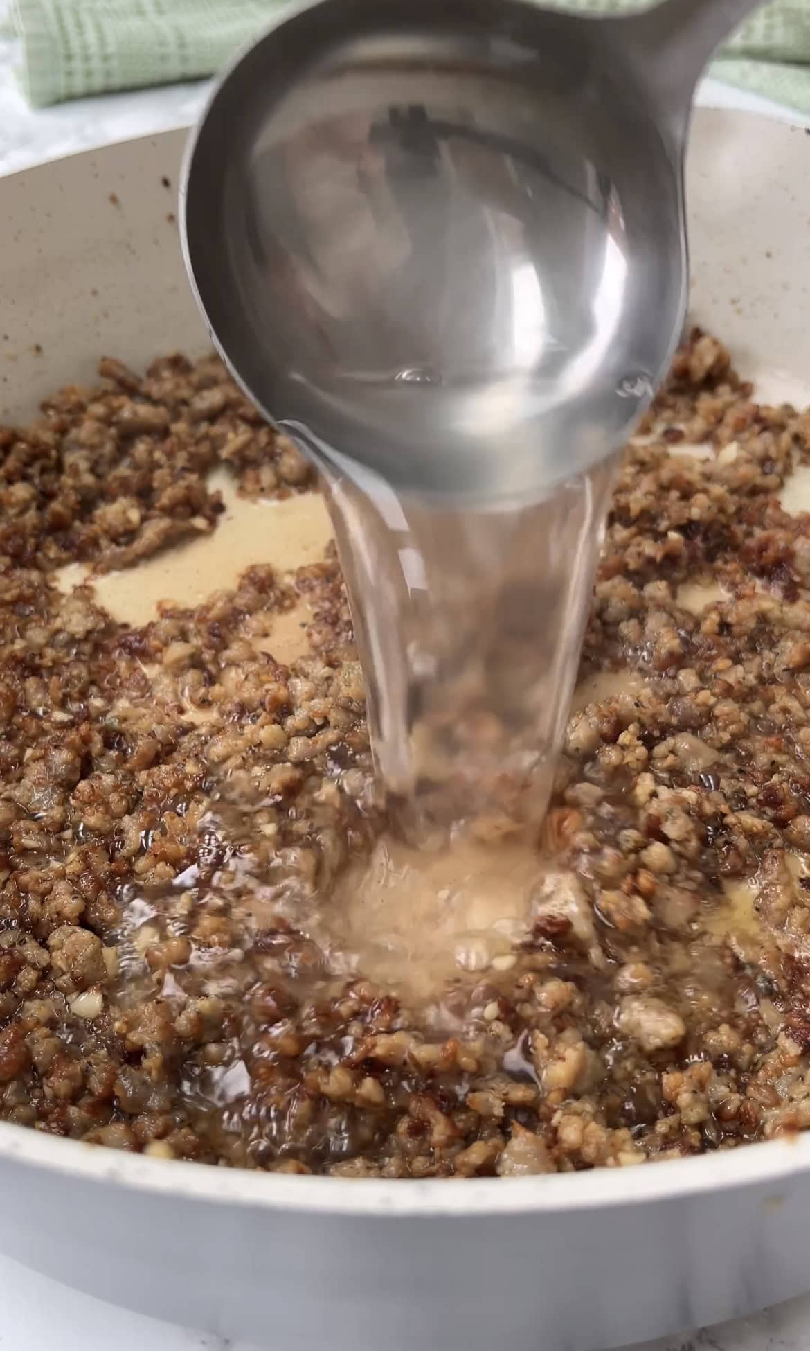 adding pasta water to the sauce.