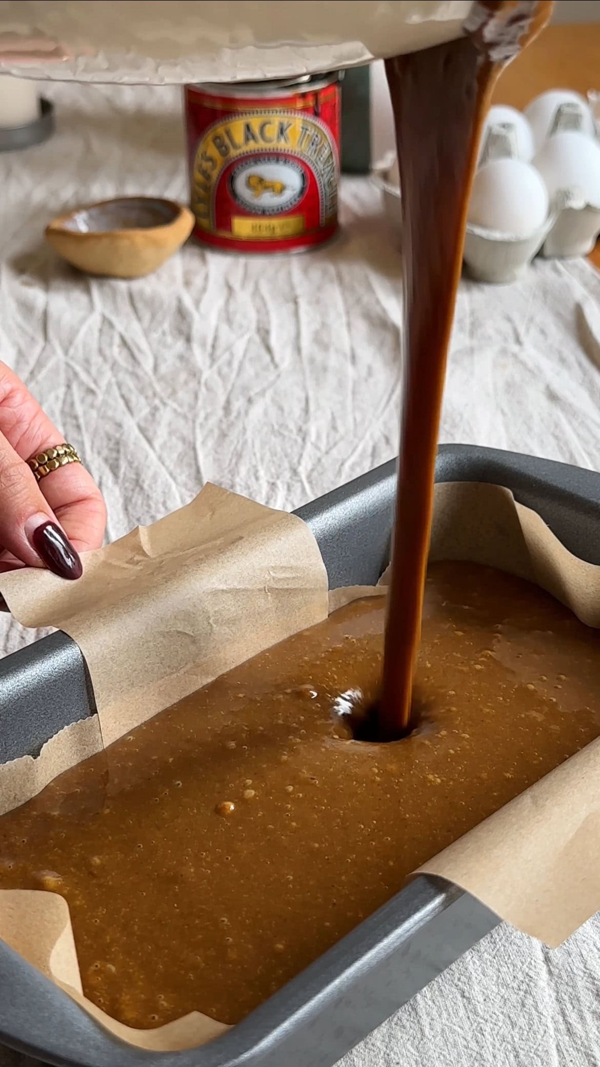 pouring jamaica ginger cake batter into tin.