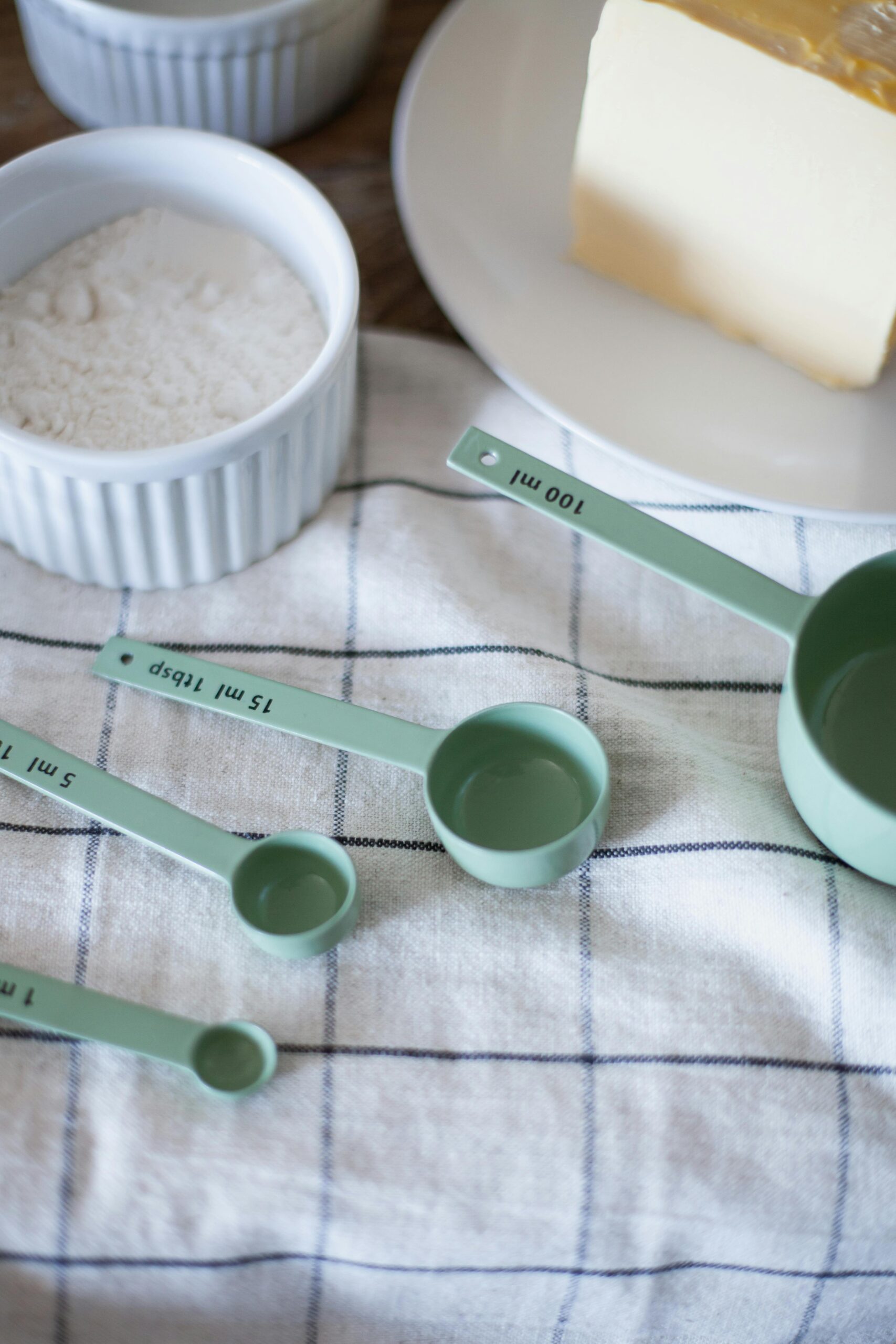 measuring cups on a tea towel with ounces of flour before.