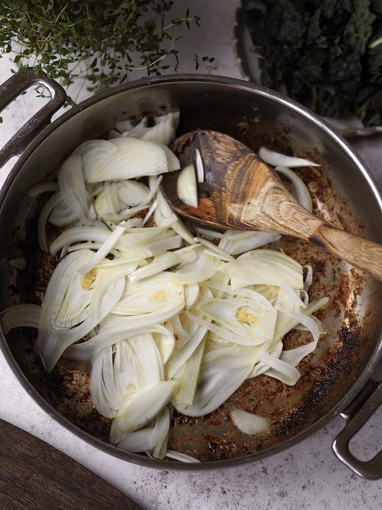 Sliced fennel in a frying pan.