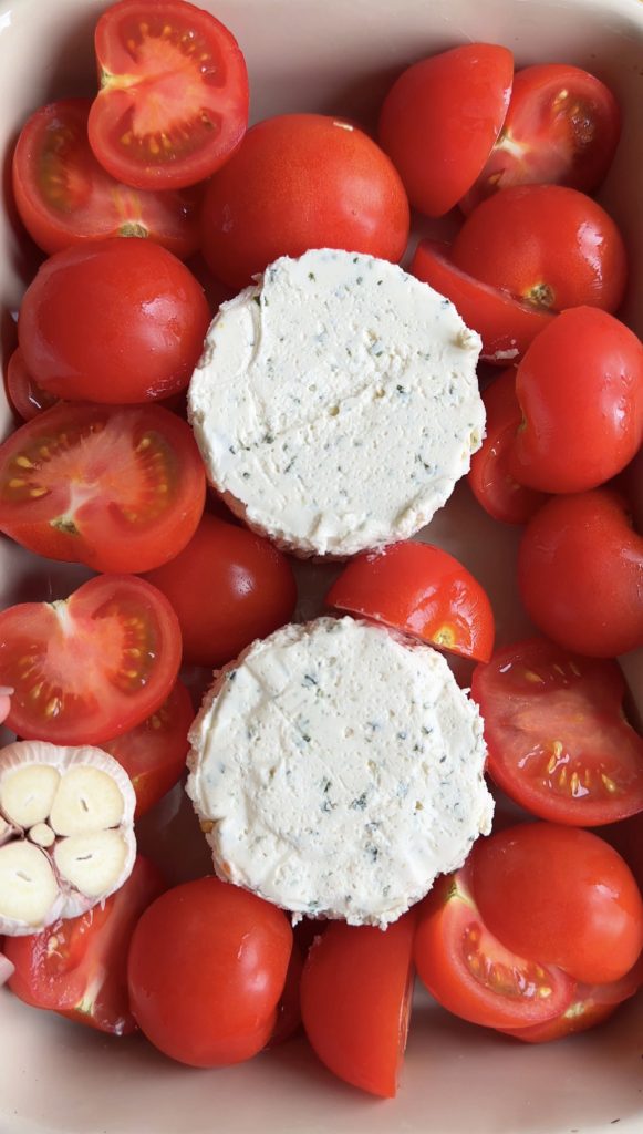 uncooked boursin, tomatoes and garlic in a roasting pan