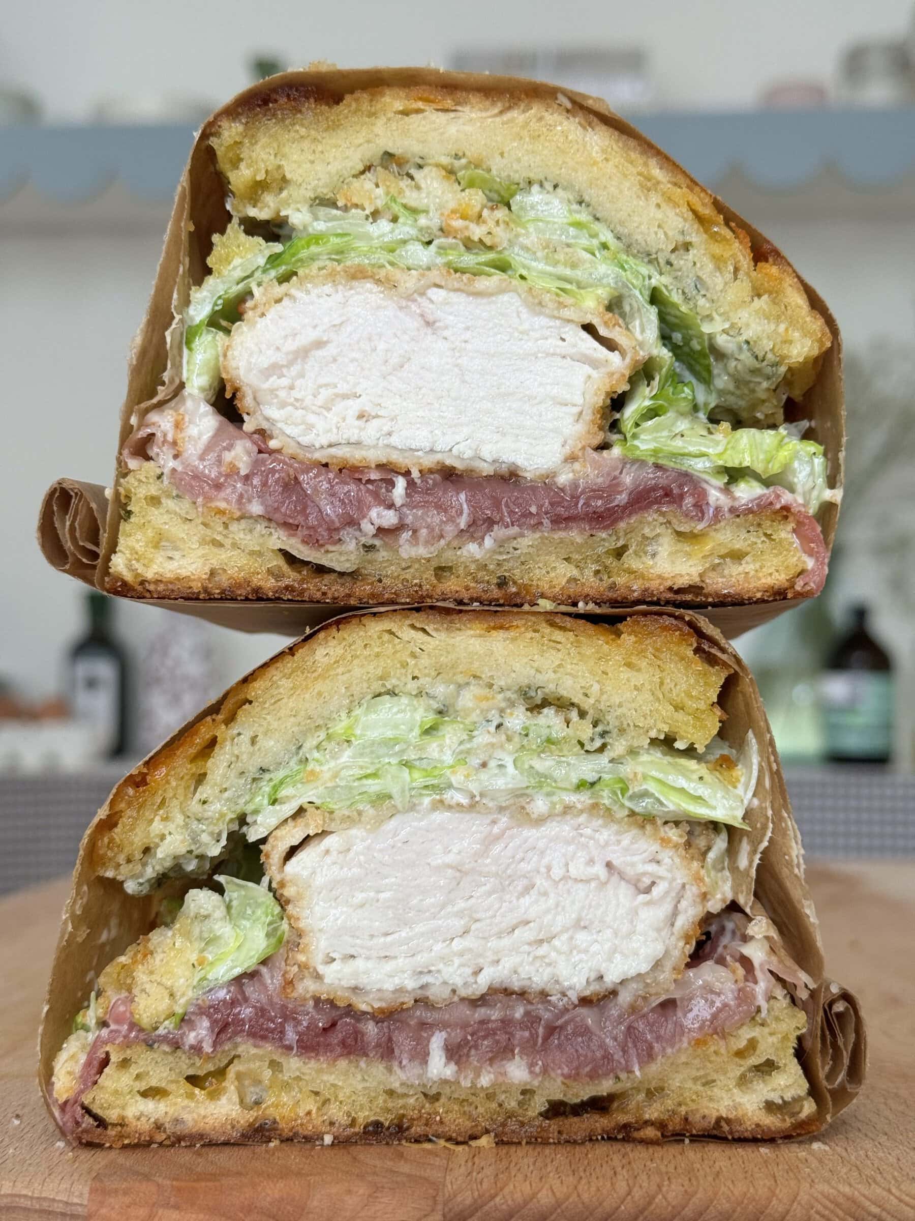 cross section of a chicken caesar sandwich stacked on top of one another