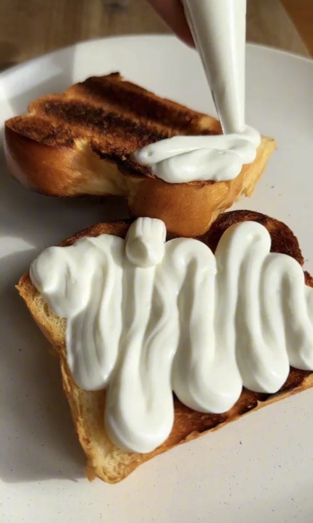 Piping whipped ricotta onto brioche toasts