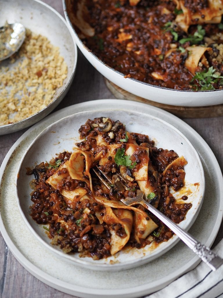 Bowl of lentil bolognese with pappardelle pasta.