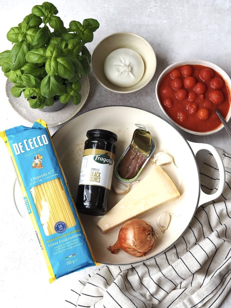 Puttanesca ingredients on a white worktop.