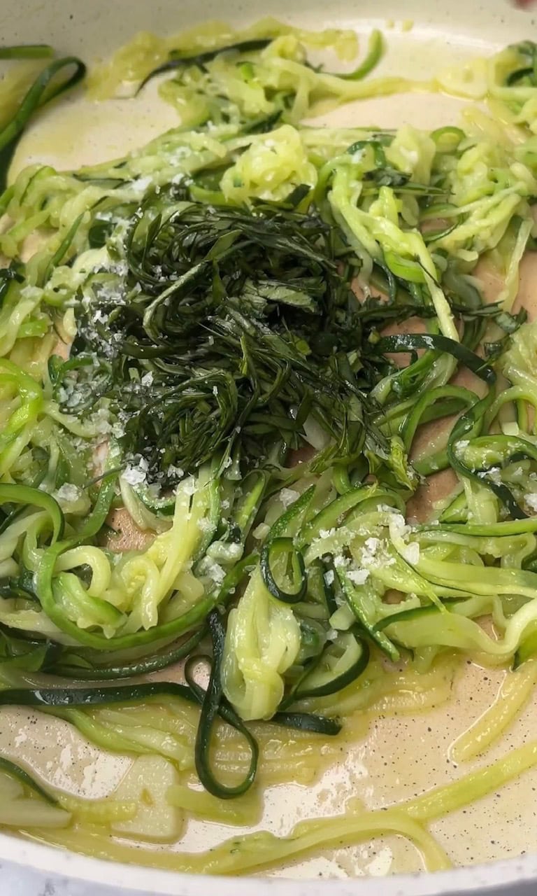 adding basil to courgette carbonara.