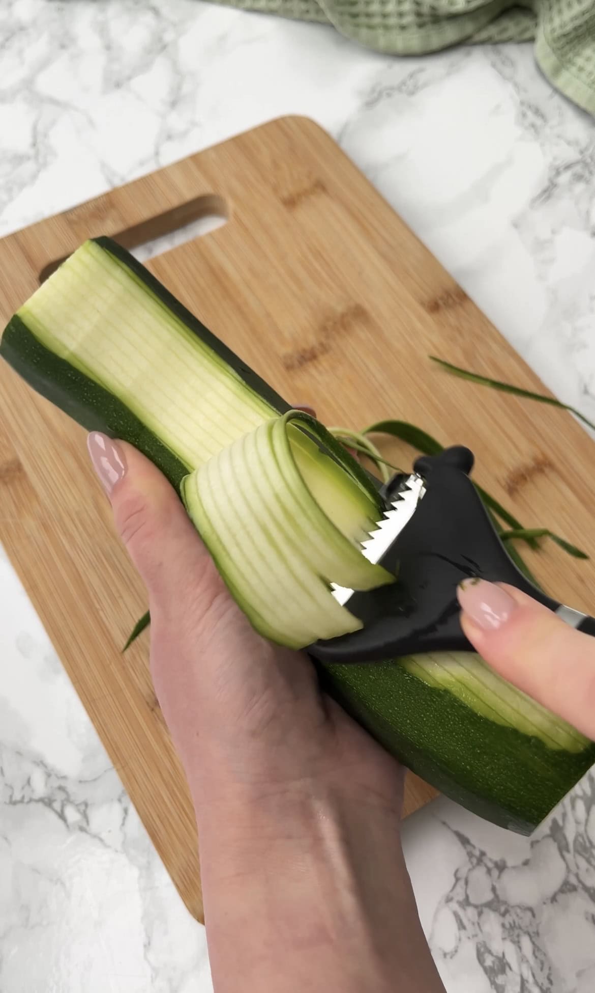 using a julienne peeler with a courgette.