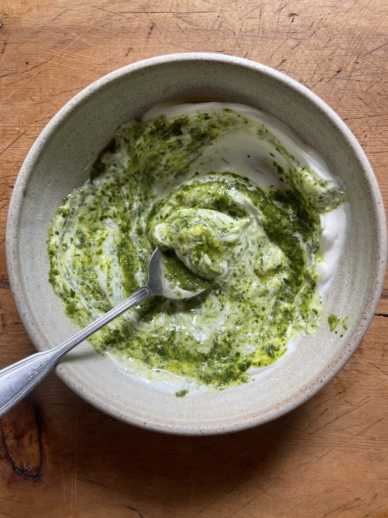 a grey bowl of chimichurri yoghurt with a spoon