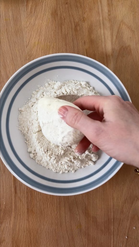 woman breading mozzarella with flour