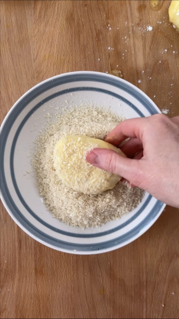 woman breading the mozzarella with panko breadcrumbs