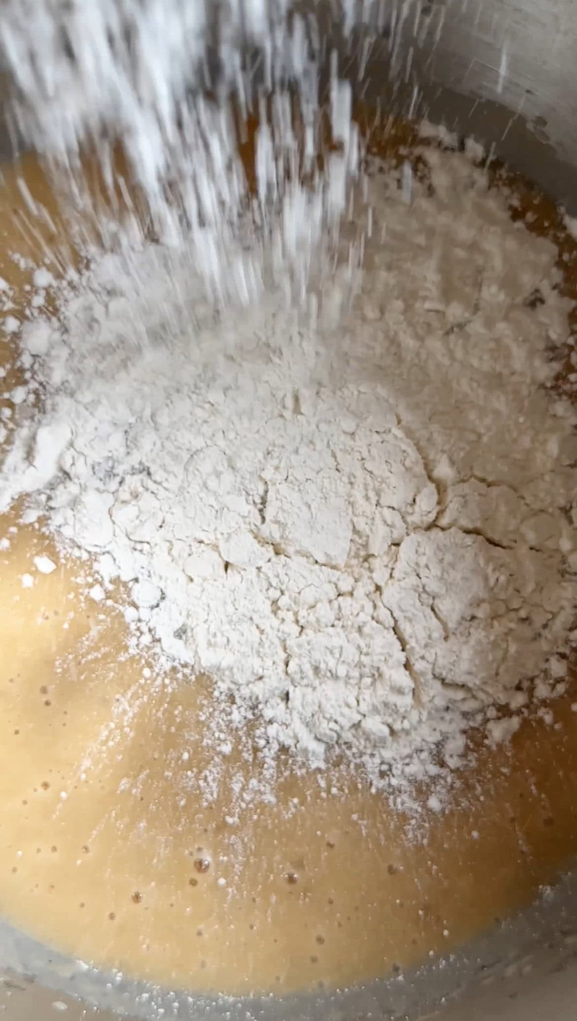 adding flour to banana bread batter.